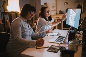 pregnant woman working in her studio with a colleague